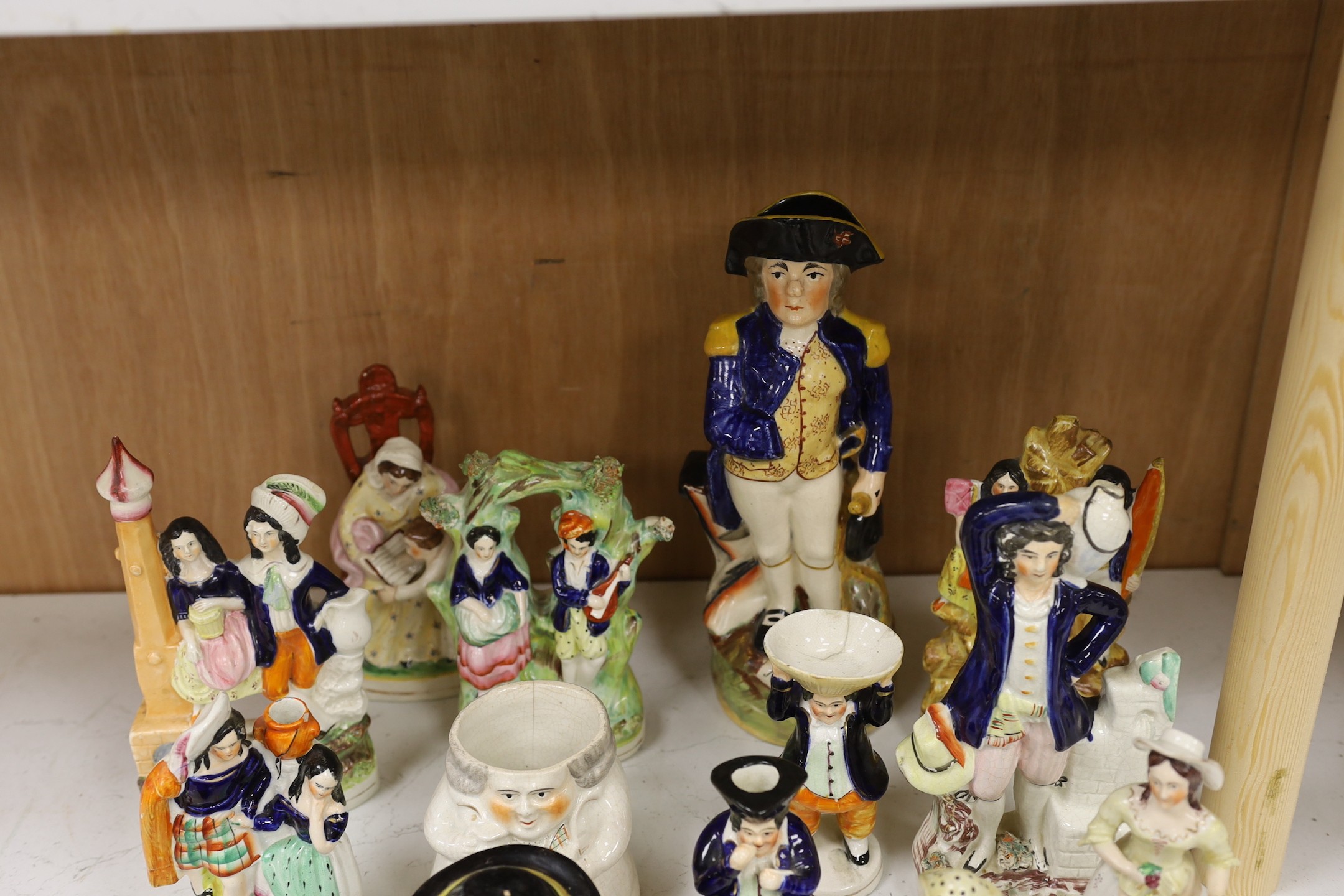 A large group of Staffordshire pottery figures and groups and figural cruets, to include a Nelson commemorative Toby jug, 31 cms high.